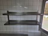 a metal shelf in the corner of a kitchen