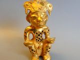 a gold figurine of a man with a bird in his hand