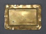 an old brass tray on a table with a black background