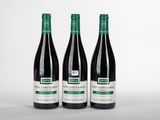 trois bouteilles de vin posées sur une table blanche