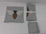 three pieces of cloth with a bee on them sitting on a bed
