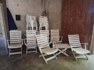 a lot of lawn chairs and umbrellas in a room