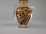 a small glass bottle with a painting on it
