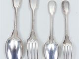 four silver spoons and a fork on a white surface