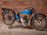 a blue motorcycle that is parked in front of a brick wall