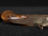 pair of antique wooden hand guns on a black background