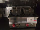 two deep fryers sitting on the counter in the kitchen