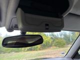 a rear view mirror of a car with a view of a field in the background