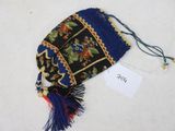 un petit sac orné d'un pompon, posé sur une surface blanche