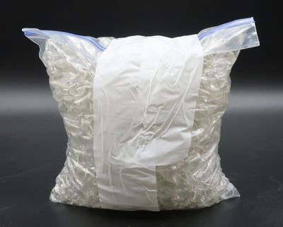 un grand sac rempli de sacs en plastique blancs posé sur une table