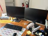un bureau sur lequel sont posés deux écrans d'ordinateur et un clavier