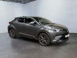 a grey toyota c - hr suv parked in a showroom