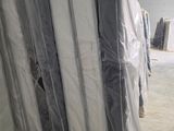 de nombreux matelas emballés dans du plastique dans un entrepôt
