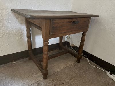a small wooden table with a drawer on it