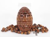a close up of a wooden egg surrounded by beads
