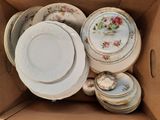 a box full of china plates and bowls in it