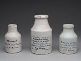 trois vases blancs posés les uns à côté des autres sur une table
