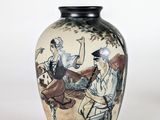 a vase with a painting on it sitting on a table