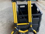 un diable jaune et noir sur lequel est posée une caisse noire