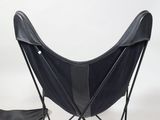 a black chair and a black cowhide rug on a white background