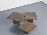 three small wooden tables sitting on top of a gray floor
