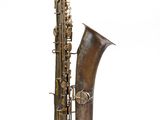 un vieux saxophone avec un corps en laiton et un pavillon, sur fond blanc