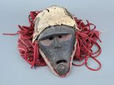 un masque entouré d'un cordon rouge sur un fond gris