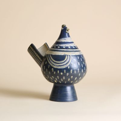 une théière bleue et blanche contenant une cuillère