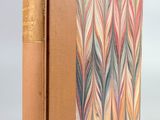 un livre marron à la couverture colorée posé sur une table