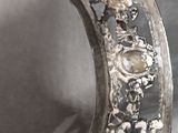 a person holding a silver ring with flowers on it