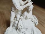 une figurine représentant un homme en train de couper les cheveux d'une femme