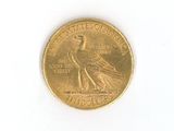 a gold coin with a bird on it on a white surface
