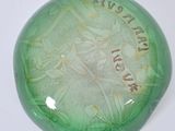 a green glass object with a picture of a woman on it