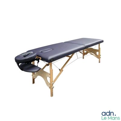 a black massage table sitting on top of a wooden table