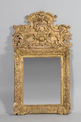 un miroir en or richement décoré, surmonté d'une tête de lion
