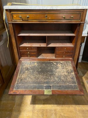 un bureau en bois avec un plateau en marbre dans une pièce