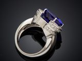 a close up of a blue sapphire and diamond ring on a black surface