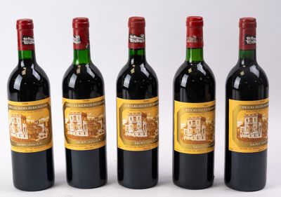 quatre bouteilles de vin sont alignées sur une surface blanche