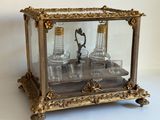 une vitrine contenant trois bouteilles, posée sur une table