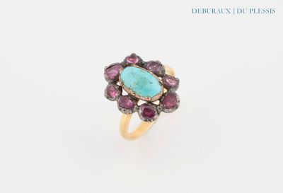 an image of a ring with a turquoise stone surrounded by pink sapphires