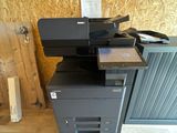 une imprimante noire posée sur une pile de cartons