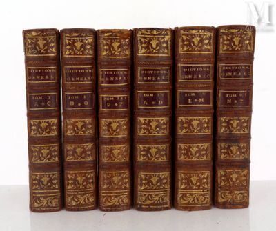 six vieux livres sont alignés sur une surface blanche