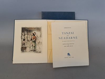 un livre ouvert posé sur une table, à côté d'un livre bleu