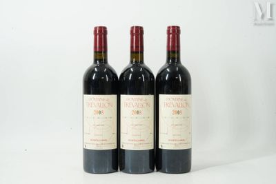 trois bouteilles de vin rouge sont alignées sur une surface blanche