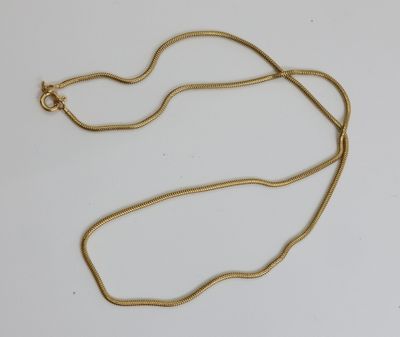un collier plaqué or avec une longue chaîne sur un fond blanc