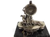 a silver clock on a marble base with a statue of a man and a dog