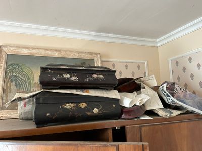 Plusieurs valises sont empilées sur une commode dans une pièce.