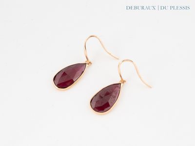 une paire de boucles d'oreilles en pierre rouge sur fond blanc