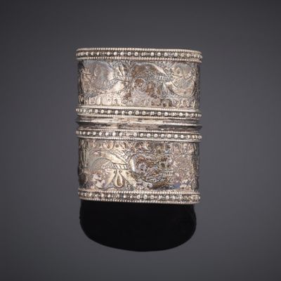 a close up of a silver ring on a black surface