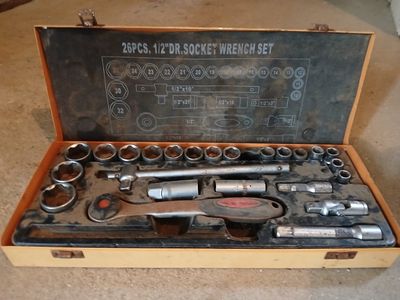 une boîte contenant des outils posée sur le sol